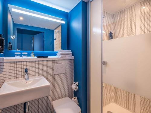W łazience znajduje się umywalka i prysznic. w obiekcie ibis budget Nantes Nord Treillières w mieście Treillières