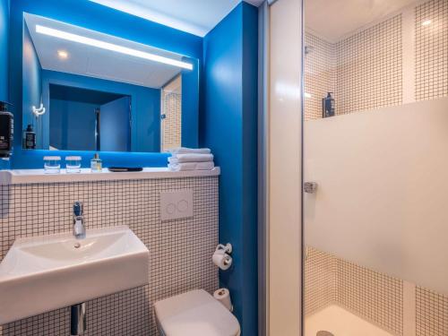 a bathroom with a sink and a shower at ibis budget Nantes Nord Treillières in Treillières