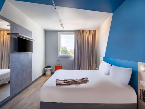 pokój hotelowy z łóżkiem z drewnianym przedmiotem w obiekcie ibis budget Nantes Nord Treillières w mieście Treillières