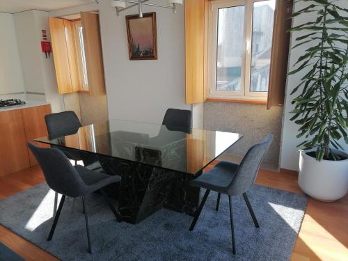 a dining room table with chairs and a potted plant at Garrett Houses in Póvoa de Varzim