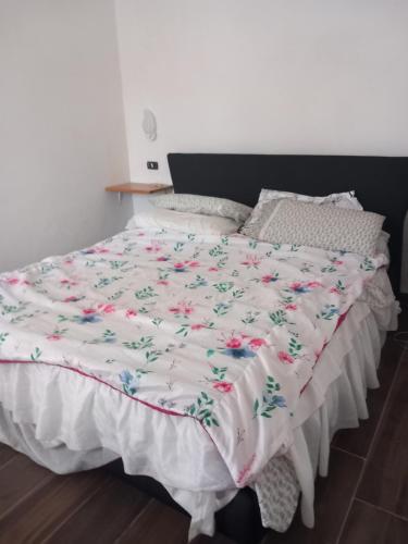 uma cama com uma colcha branca com flores em Casa tiziana em Terracina