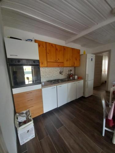 uma cozinha com electrodomésticos brancos e armários de madeira em Casa tiziana em Terracina