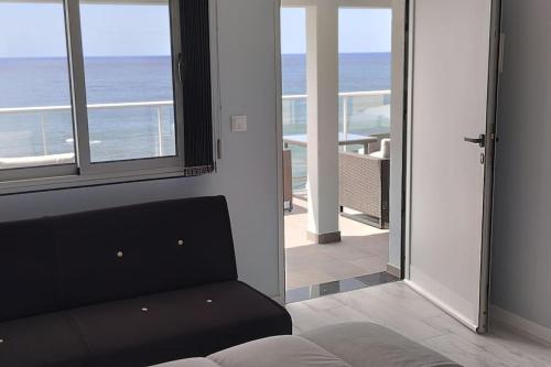 Una sala de estar con un sofá y vista al mar. en Apt 'A Gaioa' in 'The Cliff Coast Accomodation', en Paul do Mar