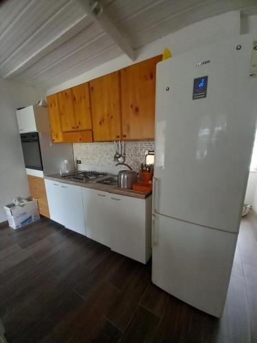 uma cozinha com um frigorífico branco e armários de madeira em Casa tiziana em Terracina