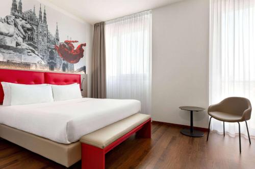 a bedroom with a large bed with a red headboard at Amedia Hotel Milan, Trademark Collection by Wyndham in Milan