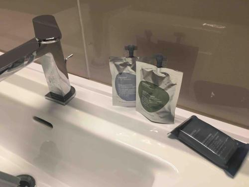 ein Waschbecken mit zwei Flaschen Seife und einem Spiegel in der Unterkunft casa vacanze via della seta in Lauria Inferiore