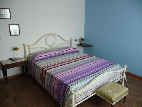 ein Schlafzimmer mit einem Bett mit gestreifter Decke in der Unterkunft casa vacanze via della seta in Lauria Inferiore