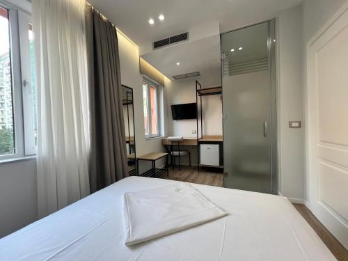 a bedroom with a bed and a sliding glass door at Enzo rooms & apartment Blloku in Tirana