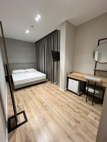a bedroom with a bed and a desk in it at Enzo rooms & apartment Blloku in Tirana