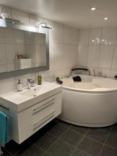 a white bathroom with a tub and a sink at Hybel med bad in Egersund