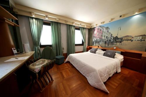a hotel room with a bed and a desk at HR Hotel in Monfalcone