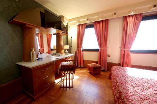 a bedroom with a bed and a vanity with a sink at HR Hotel in Monfalcone