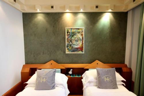 a bedroom with two beds and a green wall at HR Hotel in Monfalcone