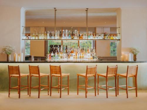 a bar with four chairs and a counter at Hyde Ibiza in Cala Llonga