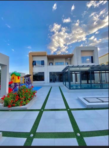 a large building with a playground in front of it at استراحة رافلز in Sayq