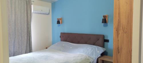 um quarto com uma cama e uma parede azul em Apartment in Bozdosh estate em Uzhhorod