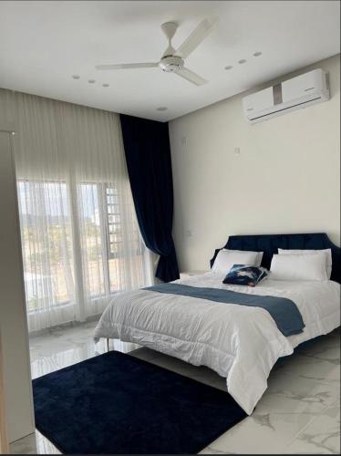 a bedroom with a bed with a ceiling fan at استراحة رافلز in Sayq