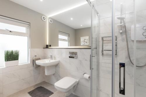 a bathroom with a shower and a toilet and a sink at Cheerful 3 bed in the heart of Fethard village in Fethard on Sea