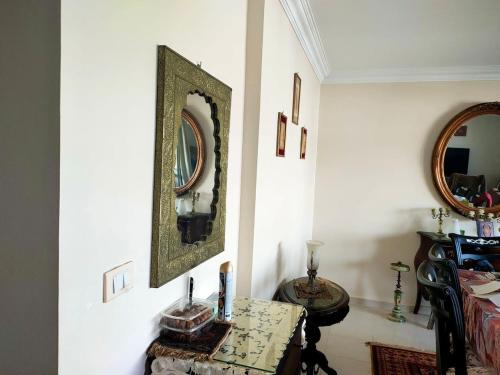 een kamer met een tafel en een spiegel aan de muur bij Cozy apartment with an excellent garden view in Caïro