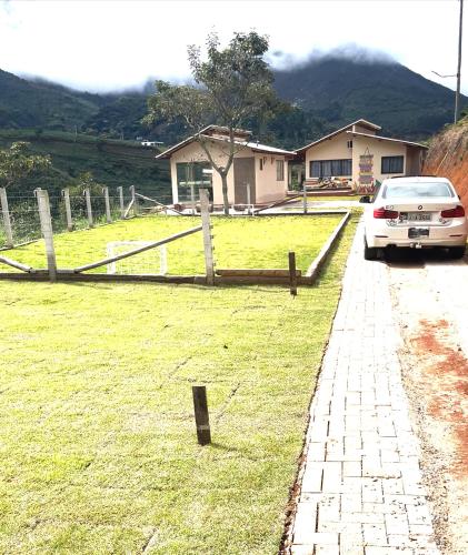 un'auto parcheggiata accanto a un campo con recinto di Refúgio do ipê (Barboza & Castro) a Espera Feliz