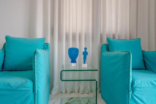 a blue couch and a table with a vase on it at Infinity View Apartment in Naxos Chora