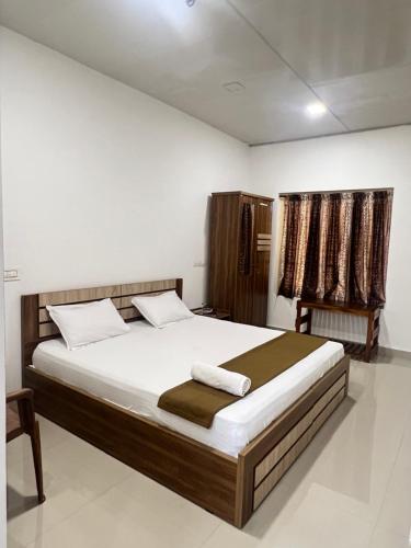 een slaapkamer met een groot bed in een kamer bij sevens residency in Sultan Bathery