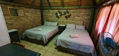 a room with two beds and a laptop in it at Pepe Piatto Lodge in Grootvlei