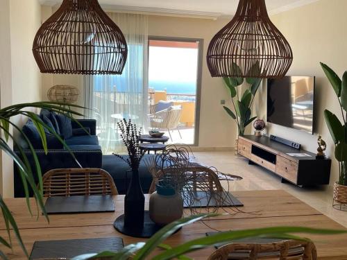 a living room with two hanging pendant lights at Panoramic Sea Views - Penthouse in Quartiers in Estepona