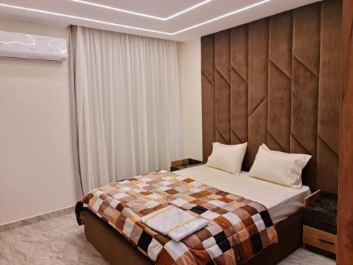 una camera con un grande letto con testiera in legno di Amazing flat front of city stars a Il Cairo