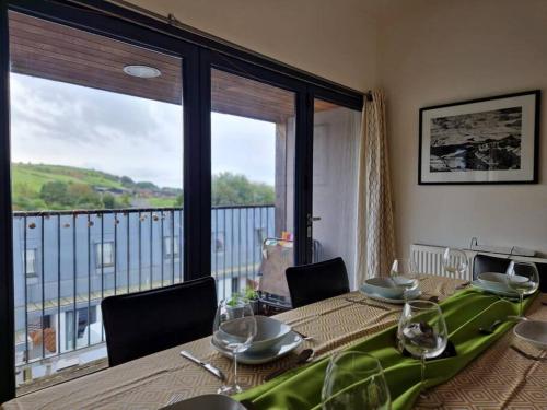 a dining room with a table and a large window at Pecket well mill in Heptonstall