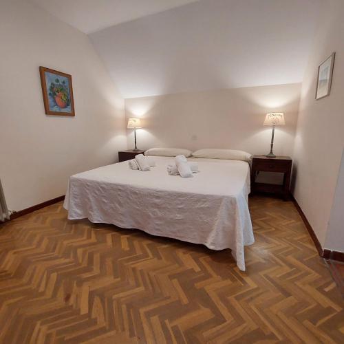 a bedroom with a large white bed with two lamps at Puente Canto de Gredos in Arenas de San Pedro