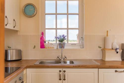 a kitchen with a sink and a window at The Bothy - Charming home on a working farm in Faversham