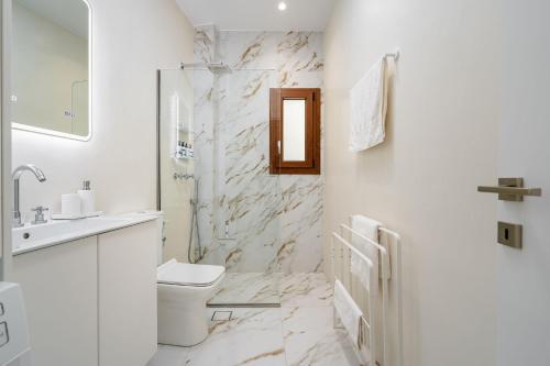 een witte badkamer met een toilet en een wastafel bij Infinity View Apartment in Naxos Chora