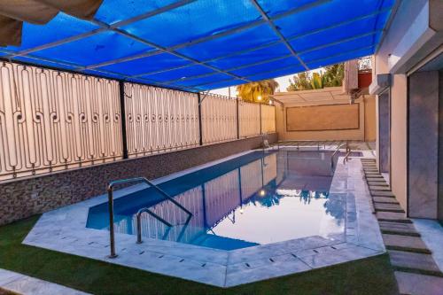 an indoor swimming pool with a blue ceiling at The Villa 604 Powered by look in Cairo