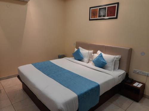 a bedroom with a large bed with blue and white pillows at Clarks Inn Dudhwa in Paliā Kalān