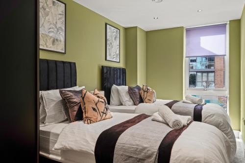 2 letti in una camera con pareti verdi di Beautiful Duplex - Sleeps 10 a Londra