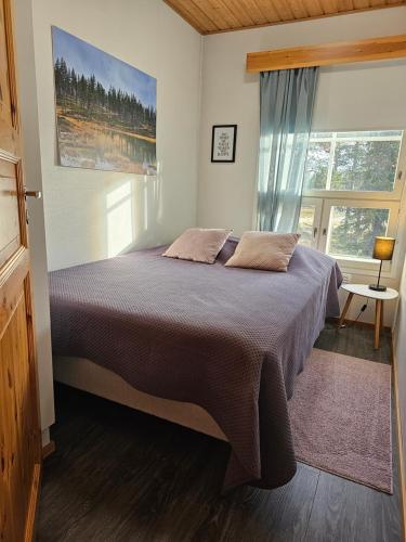 a bedroom with a bed and a large window at Rakovalkia Apartment in Saariselka
