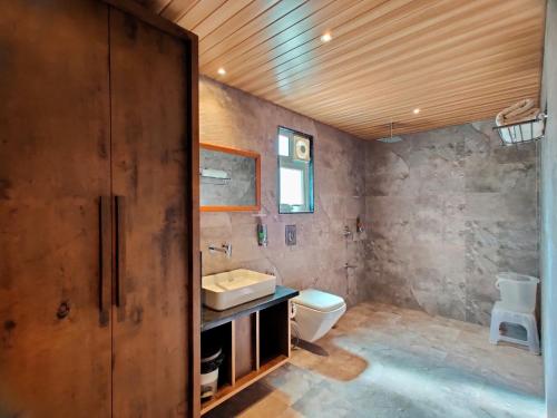 een badkamer met een wastafel en een toilet bij Lion Signature Family Resort in Sasan Gir