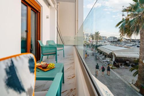 a balcony with green chairs and a view of a street at Infinity View Apartment in Naxos Chora