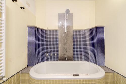 y baño con bañera y azulejos azules. en The Loft, en Roma