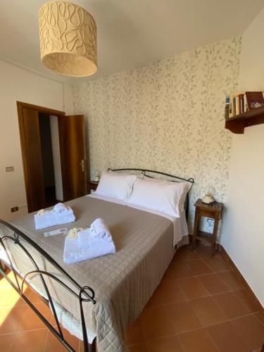 Il Tripode - Le Dimore del Bordone في Vallo di Nera: غرفة نوم عليها سرير وفوط