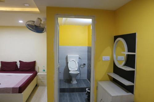a bathroom with a bed and a toilet in a room at Hotel Hill Side in Hazārībāg