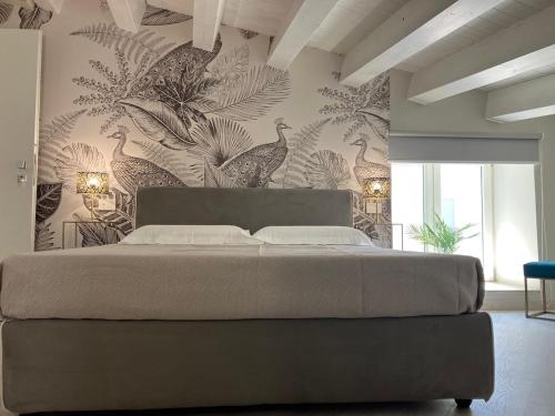 a bedroom with a bed and a wall with birds at Casa Barú Scicli in Scicli