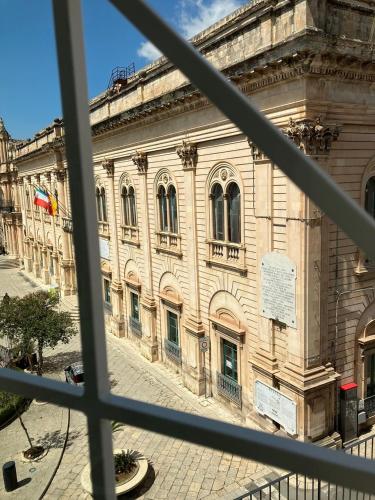 a view of a large building from a window at Casa Barú Scicli in Scicli