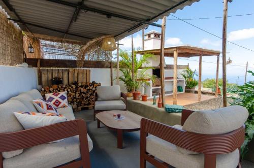 une terrasse avec deux canapés, une table et des chaises dans l'établissement Pino Redondo, à Puntagorda