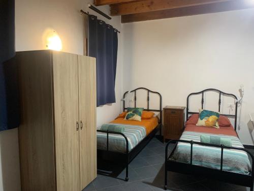 um quarto com 2 camas individuais e um armário em Monolocali del Montecontessa by SMART-HOME 