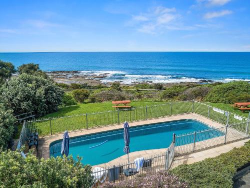 a swimming pool with the ocean in the background at 4 Whitecrest Great Ocean Road Resort - Ocean View in Wongarra