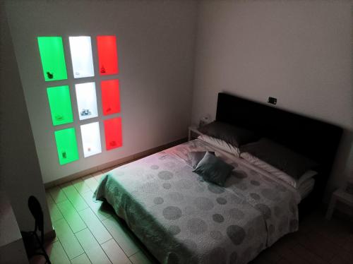 - une chambre avec un lit et des fenêtres rouges et vertes dans l'établissement Suite in città, à Naples