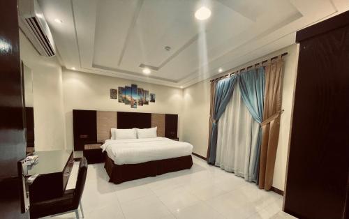 a bedroom with a bed and a desk and a window at شقق توليب الروضه للشقق المخدومة in Riyadh