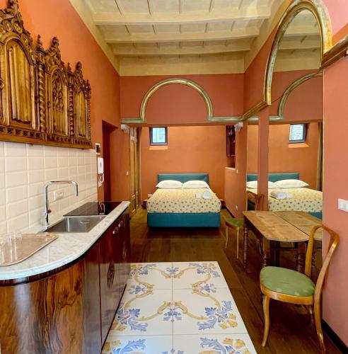 une cuisine avec évier et une chambre avec 2 lits dans l'établissement La Canonica, à Turin